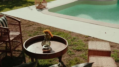 Round Wooden Side Table with Sunflower in Vase by Garden Swimming Pool Stock-Footage 343697545