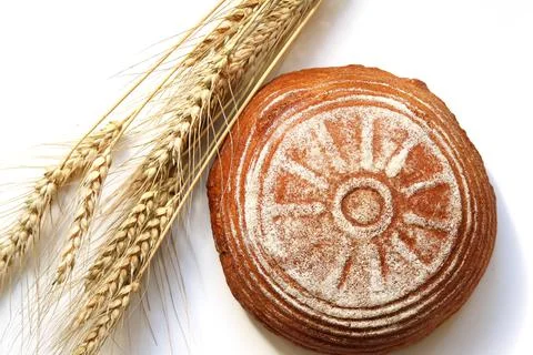 Round yeast-free rye bread and ears of rye on a white isolated background. To Stock Photos