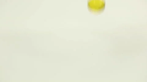 Round yellow capsules fall on the white table, bounce, crumble, the concept of Stock Footage 147977688