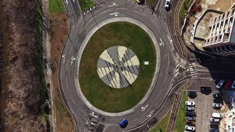 Roundabout with stone art design located in a busy city area during daytime with 스톡 동영상 331073970