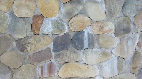 Rounded colored stones wall close up. stone walls texturel pattern Stock Photos