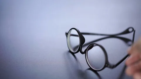 Rounded glasses picked up from black desk, start of business concept Stock Footage 120973880