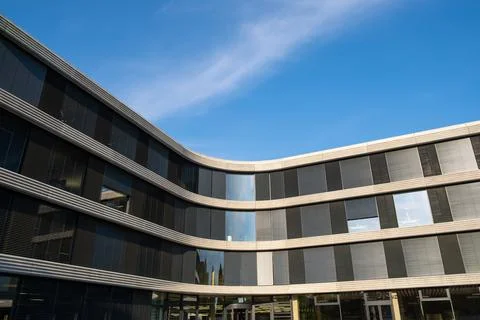 Rounded modern office building with open rooms and outdoor blinds against the Fotos de archivo