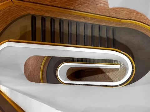 Rounded multi story interior office building staircase looking down. Fotos de archivo