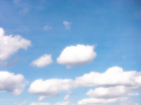 Rounded White Clouds Against a Bright Blue Background Stock Photos