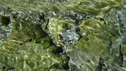 Roundish sunlight effects on the riverbed of a mountain stream Stock Footage 260842616