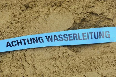Route warning tape for drinking water pipe in trench Illustrazione stock
