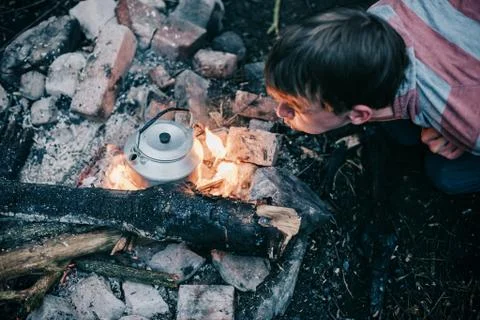 Rover blowing into campfire. High angle view. Stock Photos