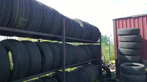 Row and stack of old used car tires. Pile of rubbish. Recycling worn tyre and Stock Photos