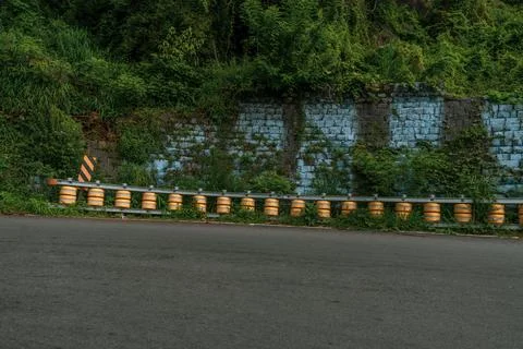 A row of barrels are lined up on the side of a road Fotos Stock