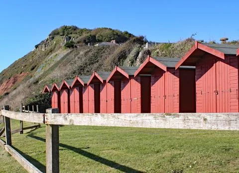 A row of beach huts on the shingle beach at Branscome in Devon, England. Stock Photos
