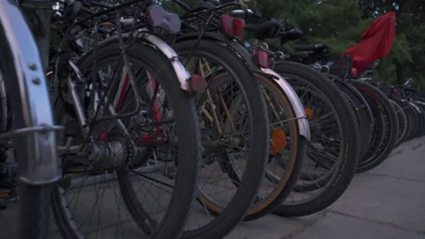 A row of bicycles connected to a bicycle rack. Walking past a row of bicycles Stock Footage 204102076