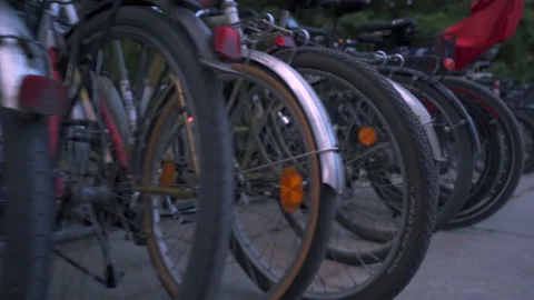 A row of bicycles connected to a bicycle rack. Walking past a row of bicycles Stock Footage 204102504