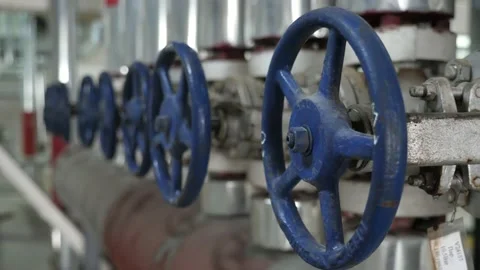 A row of big round taps  on a large tube inside of a soy bean oil plant Stock-Footage 156934941