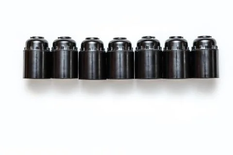Row of black plastic and ceramic electric cartriges for bulb isolated on white Stock Photos
