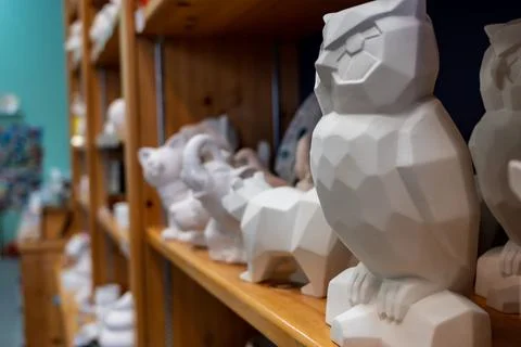 Row of blank unfinished ceramic figures on a studio shelf in a DIY store for Stock Photos