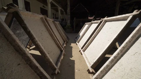 Row of blank wooden frames in sunlight against building - Luang Phabang, Laos Stock Footage 129203471