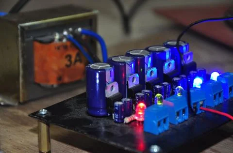 A row of blue condenser electrolyte in the voltage converter circuit Stock Photos