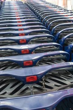 Row of blue plastic shopping carts in a store. Perspective view of empty sh.. Stock Photos