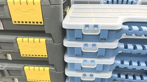 A row of blue plastic toolboxes are on a shelf. The boxes are stacked on top of Stock Photos