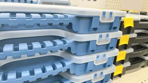 A row of blue plastic toolboxes are on a shelf. The boxes are stacked on top of Stock Photos