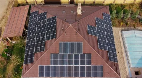 Row of blue solar panels on orange roof. Group of blue solar collectors with Foto stock