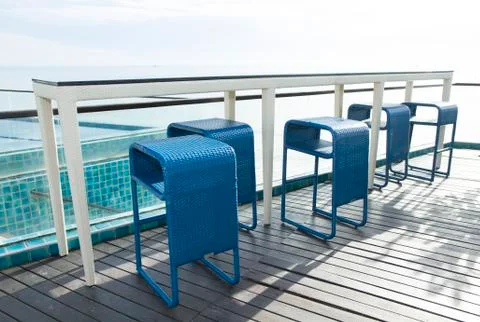 Row of blue weave bar stools with sea view in hotel or restaurant Stock Photos
