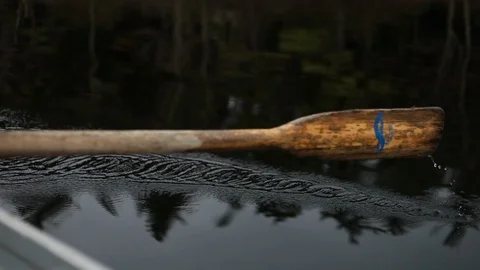 Row boat paddle moving through water with drops of water falling off Vídeo Stock 107614537