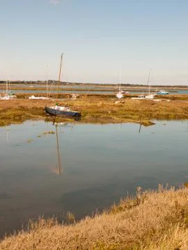 Row boats parked in stream river estuary in tollesbury maldon essex Stock Photos