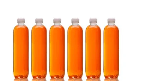 Row of bottles with orange beverage Foto stock