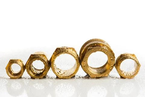 Row of brass fitting on wet table Stock Photos