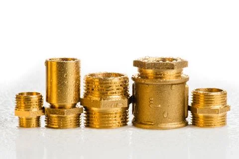 Row of brass fitting on white workshop table Stock Photos