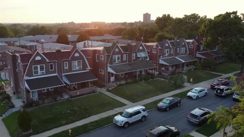 Row of brick colonial-style homes lines quiet residential street at sunset in 库存影片 340968435