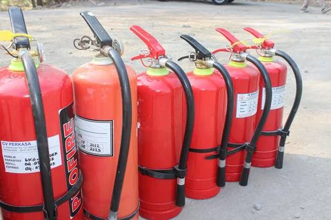 Row of Bright Red Fire Extinguishers Ready for Safety Stock Photos