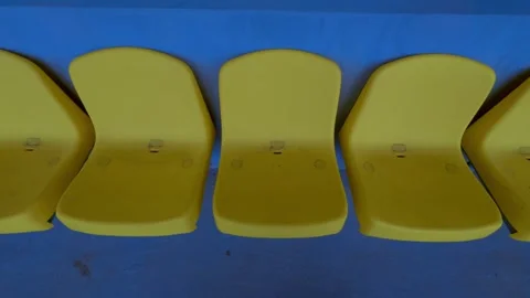 A Row of Bright Yellow Plastic Seats That Are Stylish and Inviting in Their Stock Footage 306968514
