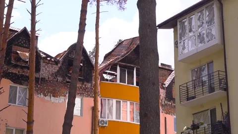 A row of buildings with trees lining their facades, after the shelling Stock Footage 264324044
