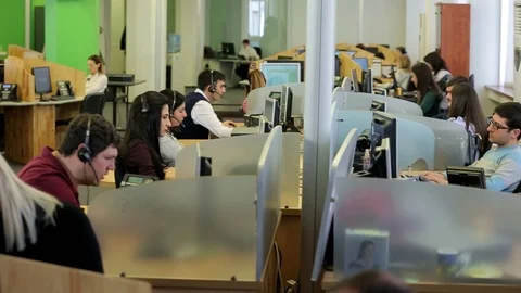 Row of call center operators at work. Customer services, telephone and computers Video stock 90902148