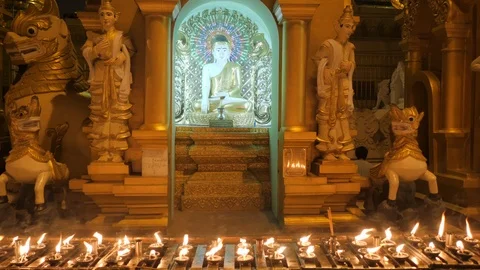 Row of candle lighting in front of buddha statue. Stockbeeldmateriaal 109669542