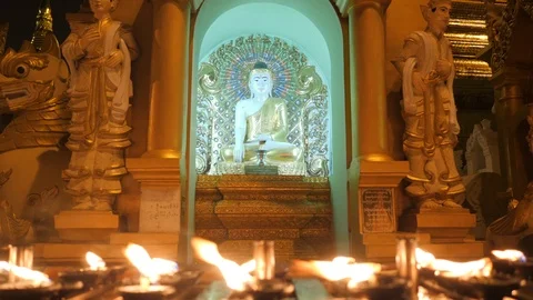 Row of candle lighting in front of buddha statue. Stock Footage 109676425