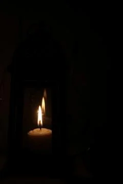 Row of candles burning in dark background Stock Photos