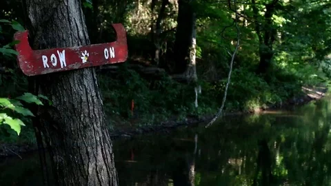 Row On Canoe Sign on Tree at Stream Stock Footage