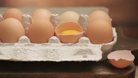 Row of chicken eggs and one egg open, side view, slider shot 4K UHD. Stock Footage 142401330