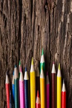 Row of colored drawing pencils closeup on old grunge natural woo Stock Photos
