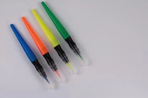 Row of colored marker brushes with transparent plastic tip on  white table Stock Photos