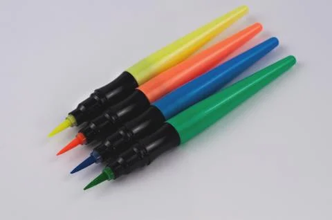 Row of colored markers brushes on white paper Stock Photos