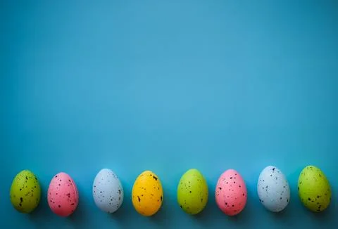 Row of Colorful Easter Eggs on Blue Background with Copy Space Foto stock