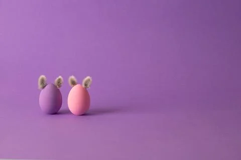 Row of colorful Easter eggs with willow bud ears painted in simple colors on  Фото