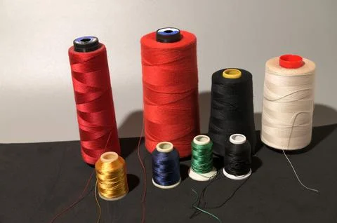 A row of colorful spools of thread Foto stock