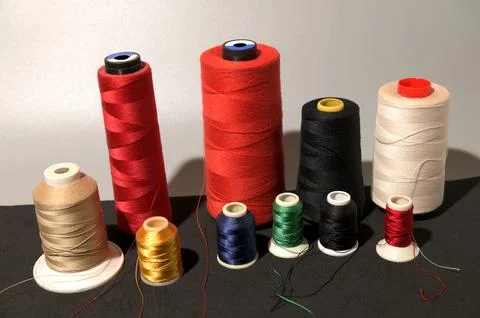 A row of colorful spools of thread Foto stock