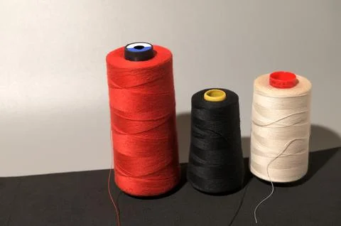 A row of colorful spools of thread Foto stock